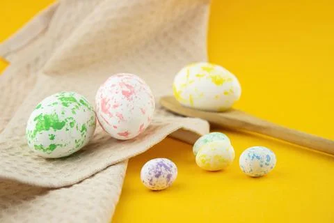 Composition of painted eggs, chicken and quail with a wooden spoon and a beig Stock Photos