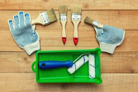 Composition from painting tools with paint brushes, gloves and paint roller o Stock Photos