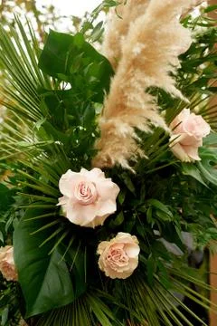 Composition of pampas grass, palm trees and roses.Decorative floristry Foto stock