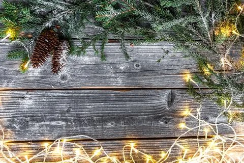 Composition of pine branches, cones, balls, garland on weathered boards.  gar Stock Photos