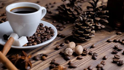 Composition of the pine cones, cup of coffee and roasted beans of coffee Video stock 129592840