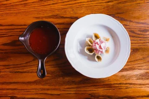 The composition of the plate with dumplings covered with pink sour cream and Stock Photos