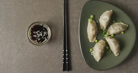 Composition of plate with gyoza dumplings and soy sauce with chopsticks on grey Stock Footage 331207667