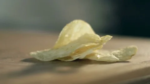 Composition of potato chips and a handful of salt on a wooden surface of table Stock-Footage 71963183