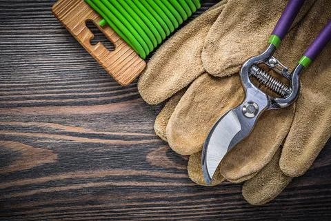 Composition of pruning shears leather safety gloves soft wire tie on wooden b Photos