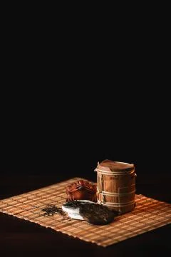 The composition of puer tea with golden toad on a bamboo mat. Black backgroun Stock Photos