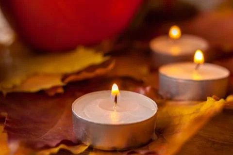 Composition with pumpkins and candles on maple leaves on wooden background. S Stock Photos