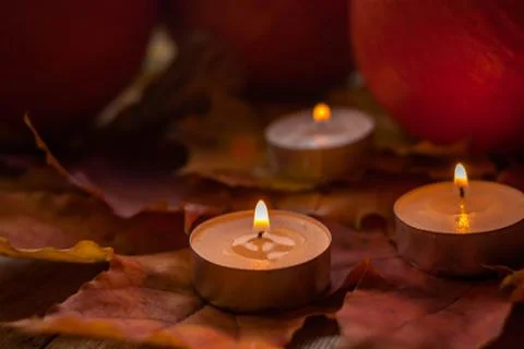 Composition with pumpkins and candles on maple leaves on wooden background. S Stock Photos