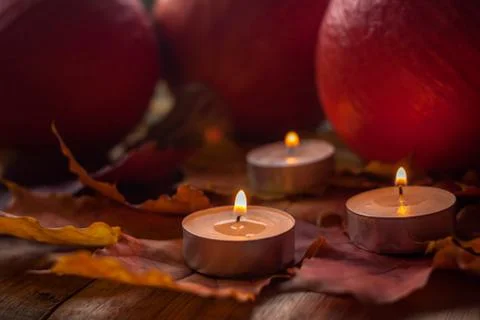 Composition with pumpkins and candles on maple leaves on wooden background. S Stock Photos
