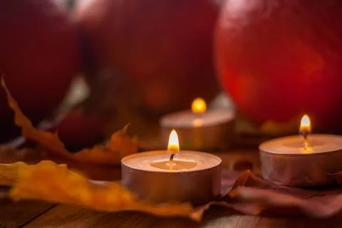 Composition with pumpkins and candles on maple leaves on wooden background. S Stock Photos
