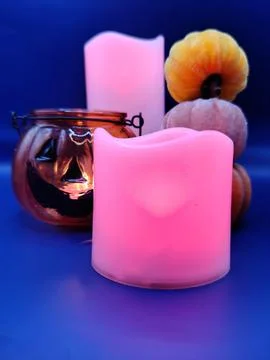 A composition of pumpkins and colored candles, macro photography. Halloween Stock Photos