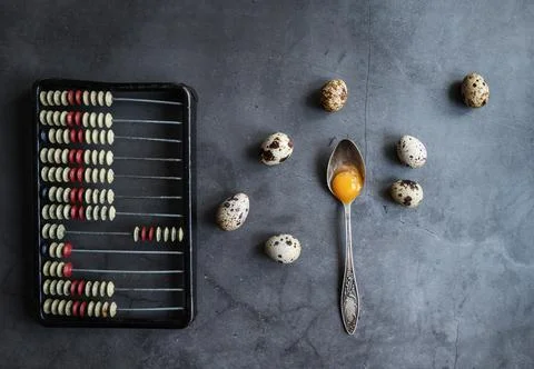 Composition with quail eggs, spoon and retro bills. The view from the top. Stock Photos
