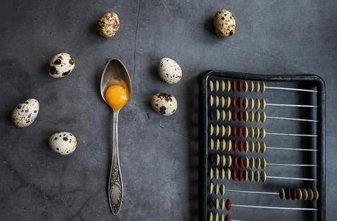 Composition with quail eggs, spoon and retro bills. The view from the top. Stock Photos
