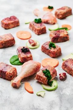 Composition with raw square cutlets and raw chicken legs on a light background Stock Photos