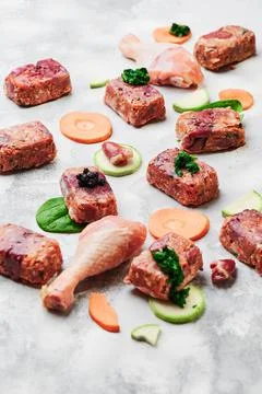 Composition with raw square cutlets and raw chicken legs on a light background Stock-Fotos