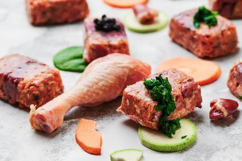 Composition with raw square cutlets and raw chicken legs on a light background Stock Photos