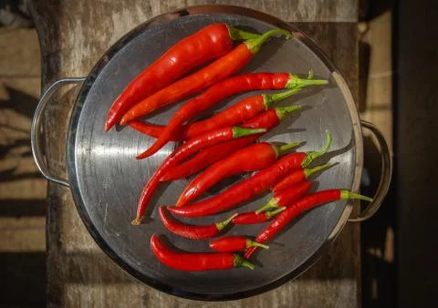 Composition of red chili pepper over a pan pot, brown background Stock Photos
