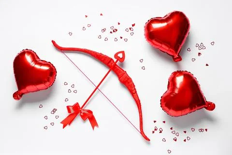Composition with red cupid's bow and heart shaped balloons on light backgroun Stock Photos