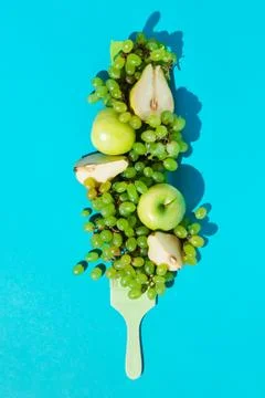 Composition with ripe grapes, pears, apples and brush colored green on blue b Stock Photos