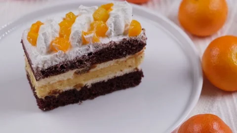 Composition of rotating tangerine or orange-chocolate brownies on a white plate Stock Footage 167332030