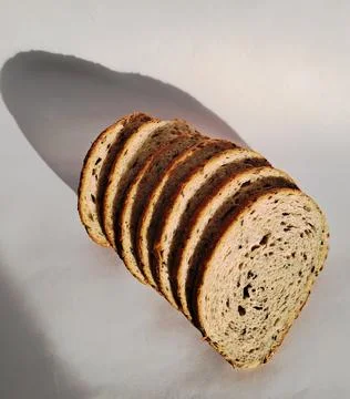 Composition of a round multigrain bread loaf sliced into pieces Stock Photos