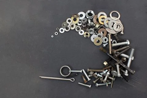 Composition of screws, washers and nuts on a gray background Stock Photos