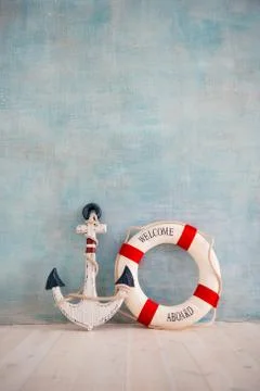A composition on a sea theme with an anchor and lifebuoy on a blue wall Stock Photos
