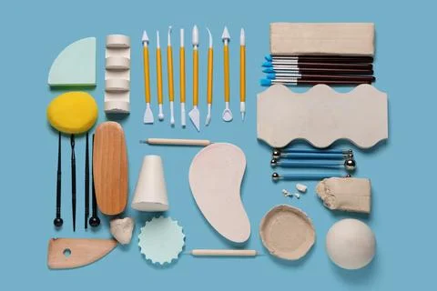 Composition with set of sculptor tools, clay and plaster figures on blue back Stock Photos