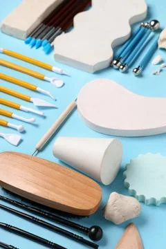 Composition with set of sculptor tools, clay and plaster figures on blue back Stock Photos