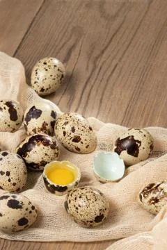 Composition of several quail eggs on decorative fabric on a wooden table clos Stock Photos