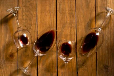 Composition with several used wine glasses with leftover liquid over wooden b Stock Photos