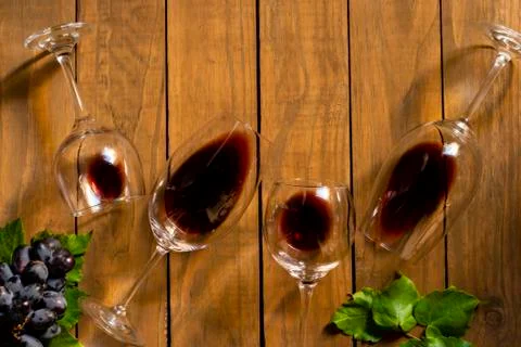 Composition with several used wine glasses with leftover liquid over wooden b Stock Photos