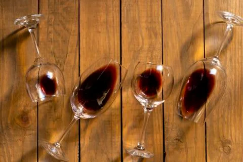 Composition with several used wine glasses with leftover liquid over wooden b Stock Photos