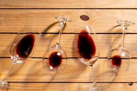 Composition with several used wine glasses with leftover liquid over wooden b Stock Photos