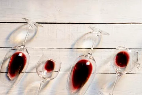 Composition with several used wine glasses with leftover liquid over wooden b 스톡 사진