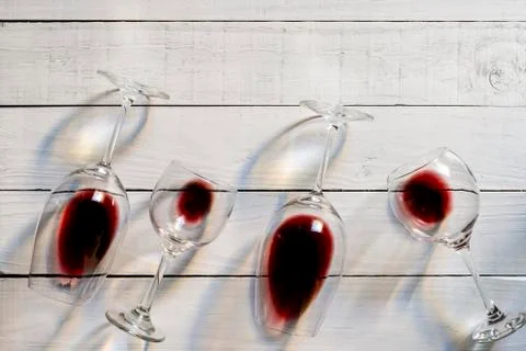Composition with several used wine glasses with leftover liquid over wooden b Stock Photos