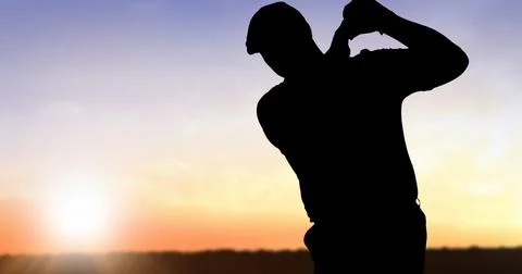 Composition of silhouette of golf player over landscape and sun on blue sky with Fotos Stock