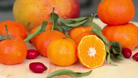 Composition with sliced oranges, mango, rosehip and green leaves, close up with Stock Footage 166132492