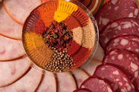 Composition of sliced sausage with condiments Stock Photos