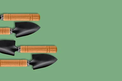 A composition of small garden blades located on a green background. Stock Photos