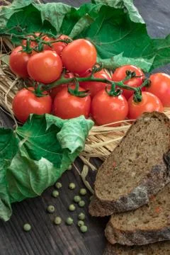 Composition of small red cherry tomatoes on an old wooden table in a rustic s Stock Photos