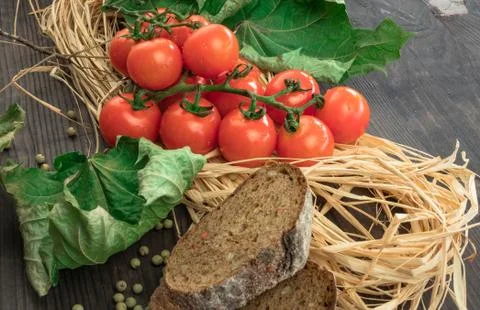 Composition of small red cherry tomatoes on an old wooden table in a rustic s Stock Photos