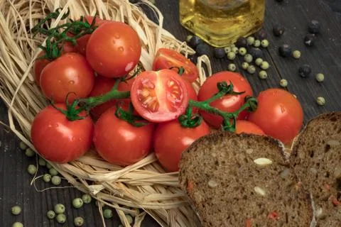 Composition of small red cherry tomatoes on an old wooden table in a rustic s Stock Photos