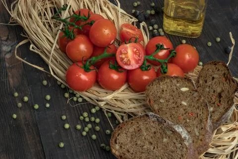 Composition of small red cherry tomatoes on an old wooden table in a rustic s Stock Photos