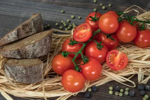 Composition of small red cherry tomatoes on an old wooden table in a rustic s Foto stock