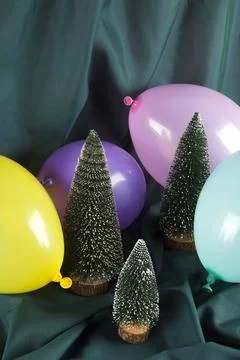 A composition of snowy Christmas trees surrounded by multicolored balloons .. Stock Photos