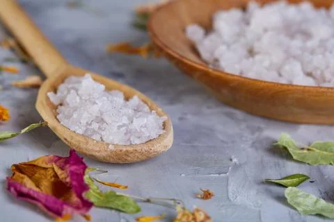 Composition of spa treatment on white background. Sea salt and flowers Stock Photos