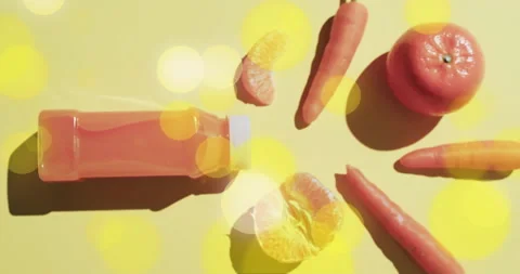 Composition of spots of light over bottle of fruit juice, carrots and oranges on Stock Footage 263916229