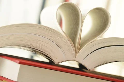 Composition with stack of books and pages formed in a shape of heart Stock Photos