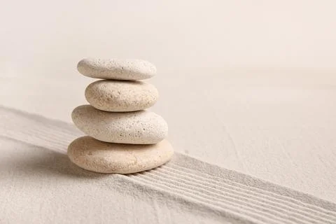 Composition with stack of spa stones and lines on sand as background, closeup Stock Photos